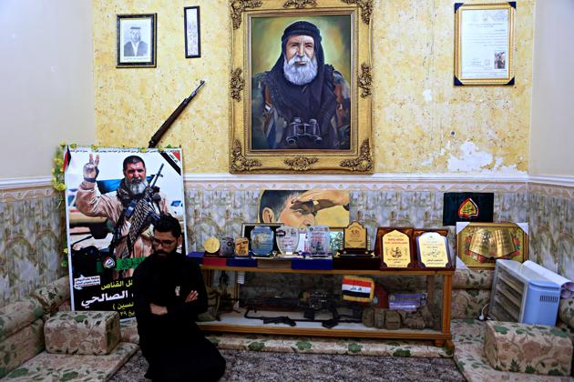 In this December 5, 2017 photo, a man sits among awards, certificates of appreciation and posters belonging to the sniper Ali Jayad al-Salhi, 65, a volunteer with Popular Mobilization Forces killed fighting Islamic State militants, in Basra, 340 miles (550 kilometers) southeast of Baghdad, Iraq. (AP) In this December 5, 2017 photo, a man sits among awards, certificates of appreciation and posters belonging to the sniper Ali Jayad al-Salhi, 65, a volunteer with Popular Mobilization Forces killed fighting Islamic State militants, in Basra, 340 miles (550 kilometers) southeast of Baghdad, Iraq. (AP)