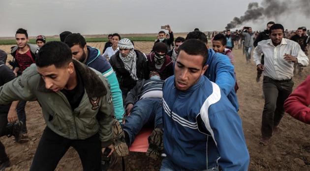 Palestinian protesters carry a wounded comrade during clash with Israeli forces near the Israel-Gaza border east of the southern Gaza strip city of Khan Yunis on December 29, 2017. (AFP Photo) Palestinian protesters carry a wounded comrade during clash with Israeli forces near the Israel-Gaza border east of the southern Gaza strip city of Khan Yunis on December 29, 2017. (AFP Photo)