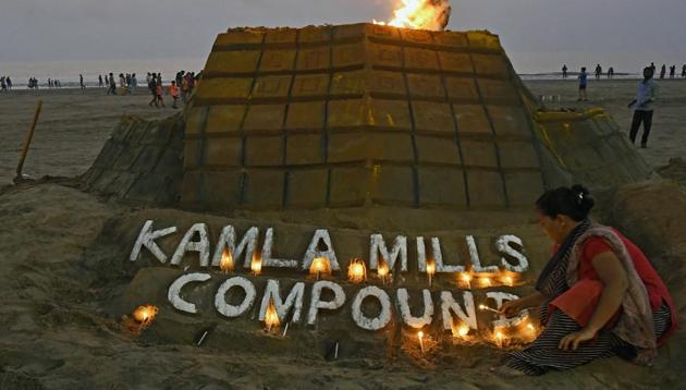 Sand artists light a candle on a structure created to commemorate victims of the Kamala Mills tragedy at Juhu Beach in Mumbai on Saturday. (Shashi S Kashyap/ HT Photo) Sand artists light a candle on a structure created to commemorate victims of the Kamala Mills tragedy at Juhu Beach in Mumbai on Saturday. (Shashi S Kashyap/ HT Photo)