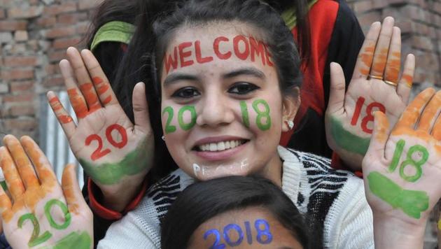 Girls with their faces painted with New Year slogans take part in celebrations in Amritsar. (Sameer Sehgal/HT)