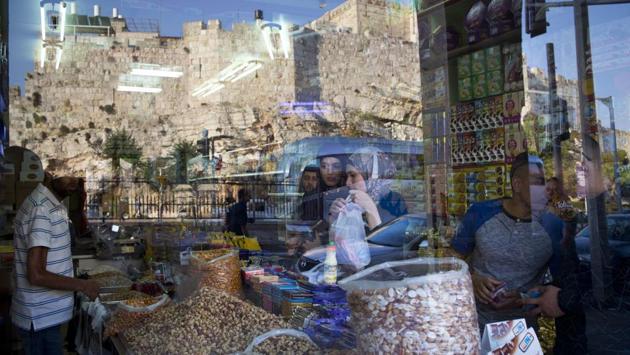 People buy items from a grocery store located between Damascus Gate and the Flowers Gate in Jerusalem’s Old City. As Israelis and Palestinians remain enmeshed in a tussle for territory and dignity, the walls of Jerusalem speak of a culturally rich and diverse city. (Oded Balilty / AP) People buy items from a grocery store located between Damascus Gate and the Flowers Gate in Jerusalem’s Old City. As Israelis and Palestinians remain enmeshed in a tussle for territory and dignity, the walls of Jerusalem speak of a culturally rich and diverse city. (Oded Balilty / AP)