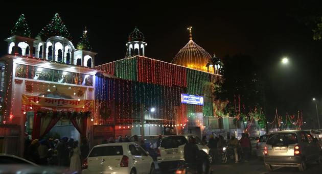 People outside an illuminated gurudwara on the New Year’s Eve. (Sanjeev Sharma/HT)