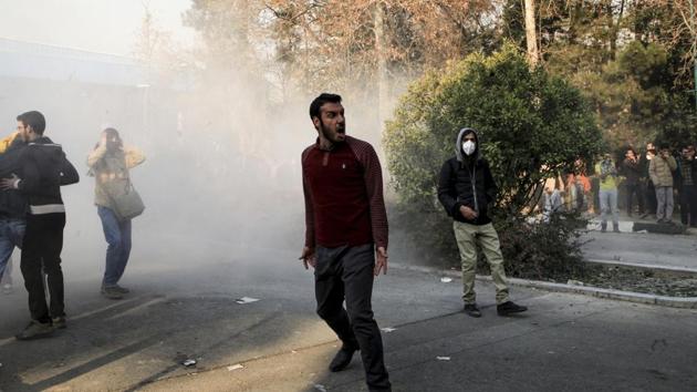 University students attend a protest inside Tehran University while a smoke grenade is thrown by anti-riot Iranian police, in Tehran. (AP) University students attend a protest inside Tehran University while a smoke grenade is thrown by anti-riot Iranian police, in Tehran. (AP)