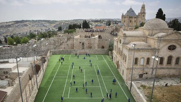 Armenian school kids play in the soccer field adjacent to Jerusalem’s Old City Walls at the Sts. Tarkmanchatz Armenian School. The iconic Old City walls have been a symbol of the city, and successive waves of conflict surrounding it for centuries. (Oded Balilty / AP) Armenian school kids play in the soccer field adjacent to Jerusalem’s Old City Walls at the Sts. Tarkmanchatz Armenian School. The iconic Old City walls have been a symbol of the city, and successive waves of conflict surrounding it for centuries. (Oded Balilty / AP)