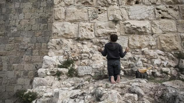 A man prays facing Jerusalem’s Old City walls between Jaffa Gate and Zion Gate. Although Trump said his declaration did not prejudge the outcome of negotiations on the city’s final borders, it was seen by the Palestinians as siding with Israel and has led to several weeks of clashes. (Oded Balilty / AP) A man prays facing Jerusalem’s Old City walls between Jaffa Gate and Zion Gate. Although Trump said his declaration did not prejudge the outcome of negotiations on the city’s final borders, it was seen by the Palestinians as siding with Israel and has led to several weeks of clashes. (Oded Balilty / AP)