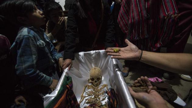A forensic anthropologist holds earrings that belonged to 6-year-old Maria Poma Perez, who was exhumed from a mass grave. Yeni De Leon of the Foundation for Forensic Anthropology, which was in charge of the exhumations, said about 45% of the 172 bodies exhumed in Santa Avelina correspond to children aged 12 and under. (Luis Soto / AP)