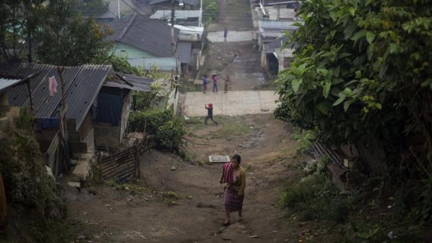 A woman walks up an unpaved road in the Ixil Mayan village of Santa Avelina.Today little has changed in Santa Avelina and poverty here is still extreme. Wood and sheet metal homes dot the hillsides, while others have been upgraded with block construction. (AP)