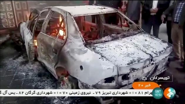 People stand near a burning car in Tuyserkan, Iran on December 31, 2017. The Fars news agency reported “scattered groups” of protesters in Tehran on Monday. Unsigned statements on social media urged Iranians to continue to demonstrate in 50 towns and cities. The government has said it was temporarily restricting access to Telegram and Instagram apps with reports that internet mobile access was also hit in some areas. (IRINN / REUTERS) People stand near a burning car in Tuyserkan, Iran on December 31, 2017. The Fars news agency reported “scattered groups” of protesters in Tehran on Monday. Unsigned statements on social media urged Iranians to continue to demonstrate in 50 towns and cities. The government has said it was temporarily restricting access to Telegram and Instagram apps with reports that internet mobile access was also hit in some areas. (IRINN / REUTERS)