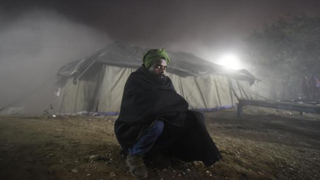 A homeless person huddles in a temporary open air theatre screening a movie on New Year’s Eve near Nigambodh Ghat. The choice of movie didn’t necessarily cater to everyone’s taste but a chance to watch one on a big screen was draw enough to step out in the biting cold. (Burhaan Kinu / HT Photo) A homeless person huddles in a temporary open air theatre screening a movie on New Year’s Eve near Nigambodh Ghat. The choice of movie didn’t necessarily cater to everyone’s taste but a chance to watch one on a big screen was draw enough to step out in the biting cold. (Burhaan Kinu / HT Photo)