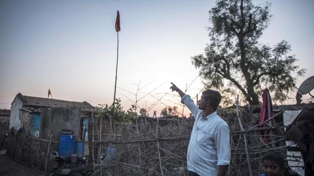 But now both sides are working together to prevent attacks. A man points towards a red flag placed by the forest department as a sign of tiger presence in the area and need for caution. Villagers are paying heed to such warnings and taking measures of their own. (Pratik Chorge / HT Photo) 