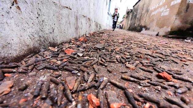 A boy walks along an alley covered with bullets ejected from an iron scrap trader's store after an explosion which razed five homes and shattered windows of surrounding buildings in the northern province of Bac Ninh.(AFP Photo)