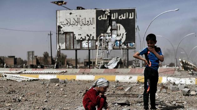This file photo taken on March 12, 2017 shows Iraqi children sitting amidst the rubble of a street in Mosul's Nablus neighbourhood in front of a billboard bearing the logo of the Islamic State (IS) group. (AFP) This file photo taken on March 12, 2017 shows Iraqi children sitting amidst the rubble of a street in Mosul's Nablus neighbourhood in front of a billboard bearing the logo of the Islamic State (IS) group. (AFP)