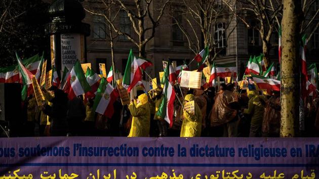 Protesters hold flags of the National Council of Resistance of Iran (NCRI) next to a banner reading "We support the insurrection against the religious dictatorship in Iran" during a demonstration in support of the Iranian people amid a wave of protests spreading throughout Iran. (AFP Photo) Protesters hold flags of the National Council of Resistance of Iran (NCRI) next to a banner reading "We support the insurrection against the religious dictatorship in Iran" during a demonstration in support of the Iranian people amid a wave of protests spreading throughout Iran. (AFP Photo)