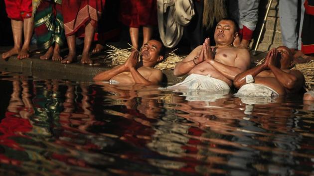 Men perform a half dip in the Hanumante River. During the month-long festival hundreds of thousands of Hindus are expected to take these dips in the holy waters on astronomically auspicious days, to pay tribute to goddess Swasthani, who is believed to bring good fortune. (Niranjan Shrestha / AP) Men perform a half dip in the Hanumante River. During the month-long festival hundreds of thousands of Hindus are expected to take these dips in the holy waters on astronomically auspicious days, to pay tribute to goddess Swasthani, who is believed to bring good fortune. (Niranjan Shrestha / AP)