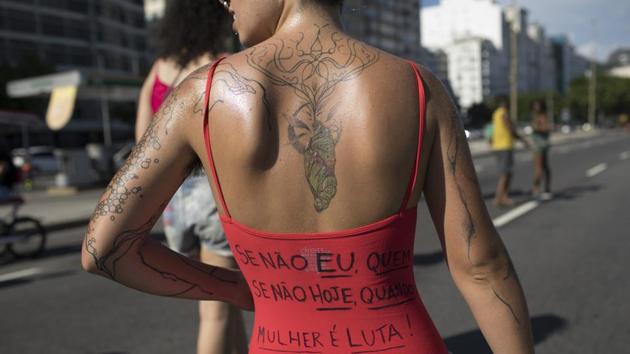 A woman wears a shirt with text reading “If not me, who? If not today, when? To be a woman is to battle!” during the annual “Slut Walk” along Copacabana beach. Jefferson Drezett, who runs the abortion and sexual violence response department at Perola Byington state hospital, said abortion services are already insufficient for women who seek them legally, for reasons ranging from poor management to pressure from politicians and religious groups. (Leo Correa / AP)