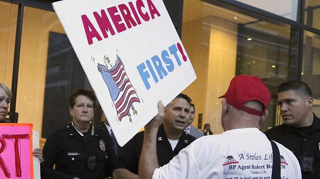 A supporter of President Donald Trump challenges police officers at a rally in LA, on January 3, 2018. Trump’s ‘Buy American, Hire American’ slogan – his push to bring jobs back into the country – has caused anxiety among foreign nationals employed in the US.(AP)