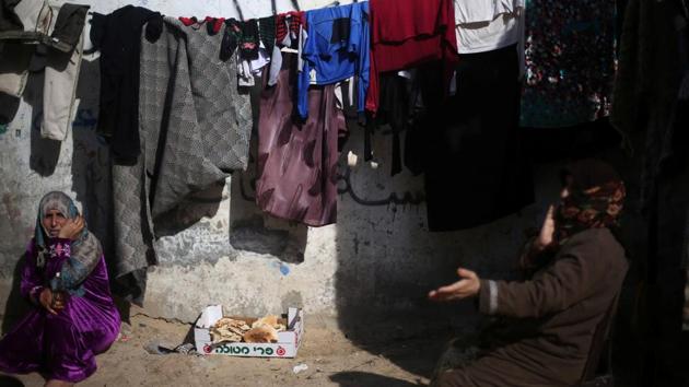 Palestinian women sit outside their house in Khan Younis refugee camp in the southern Gaza Strip on Wednesday.(Reuters)