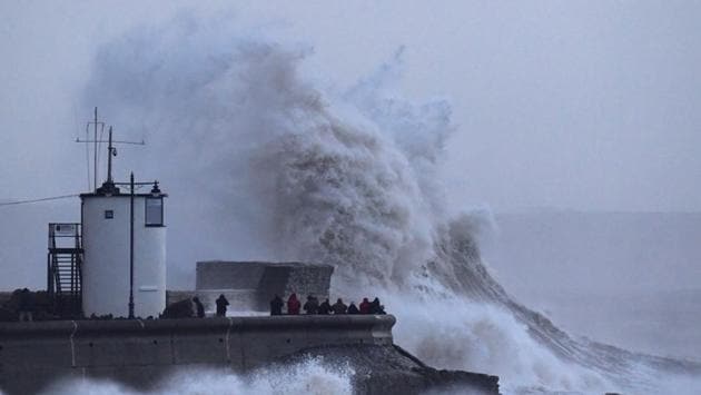 People watch large waves caused by the storm, hit a lighthouse in Britain. Extremely high tides caused the partial collapse of a harbour wall in Cornwall in southwestern England, bringing seawater in. (Toby Melville / REUTERS) People watch large waves caused by the storm, hit a lighthouse in Britain. Extremely high tides caused the partial collapse of a harbour wall in Cornwall in southwestern England, bringing seawater in. (Toby Melville / REUTERS)