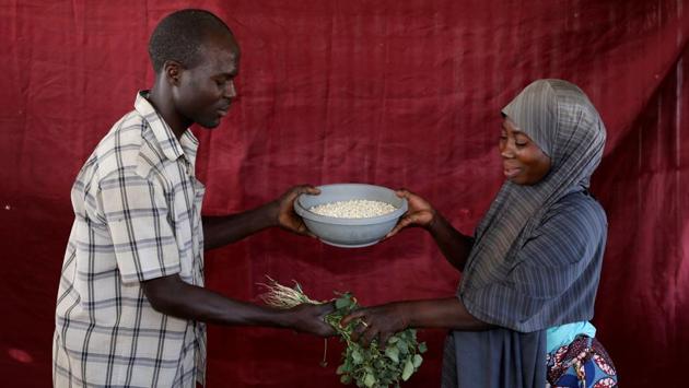 Falmata Ahmadu (R), swaps her bowl of maize for Musa Ali Wala's amaranth at the Bakasi camp. While many would prefer money, cash distribution in Nigeria’s northeast is fraught with risk. (Afolabi Sotunde / REUTERS) Falmata Ahmadu (R), swaps her bowl of maize for Musa Ali Wala's amaranth at the Bakasi camp. While many would prefer money, cash distribution in Nigeria’s northeast is fraught with risk. (Afolabi Sotunde / REUTERS)