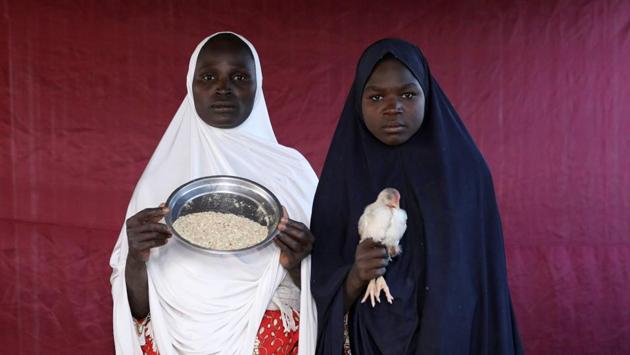 Binta Lawal (L) holds up a bowl of poultry feed with Aisha Buba at the Bakasi camp in Borno, Nigeria. The 8-year Boko Haram insurgency in Nigeria’s northeast has displaced around 2 million people, some within Nigeria and some overseas. The UN calls it one of the world’s worst humanitarian crises. In the camps, the displaced frequently swap what little they have for their preferred goods. (Afolabi Sotunde / REUTERS) Binta Lawal (L) holds up a bowl of poultry feed with Aisha Buba at the Bakasi camp in Borno, Nigeria. The 8-year Boko Haram insurgency in Nigeria’s northeast has displaced around 2 million people, some within Nigeria and some overseas. The UN calls it one of the world’s worst humanitarian crises. In the camps, the displaced frequently swap what little they have for their preferred goods. (Afolabi Sotunde / REUTERS)
