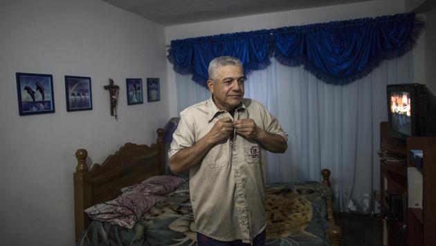 Tony Franco, 50, put on his work shirt after a Sunday lunch with his family ahead of his night shift at Ferrominera, where he has spent 28 years. Nearly two decades ago, President Hugo Chavez launched his socialist revolution. In 2008 he began putting the factories, then owned by conglomerates from Japan and Argentina, under the state’s control. Output steadily eroded even before the oil price crash. (Rodrigo Abd / AP) 
