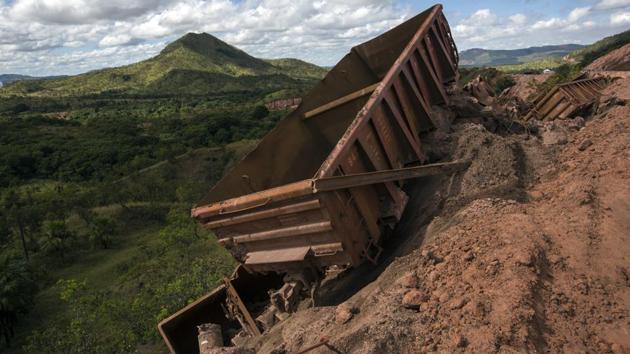 Twisted piles of train cars that once used to transport raw iron ore litter a hillside. They derailed when an engineer was travelling too fast on rails left unmaintained. (Rodrigo Abd / AP) 