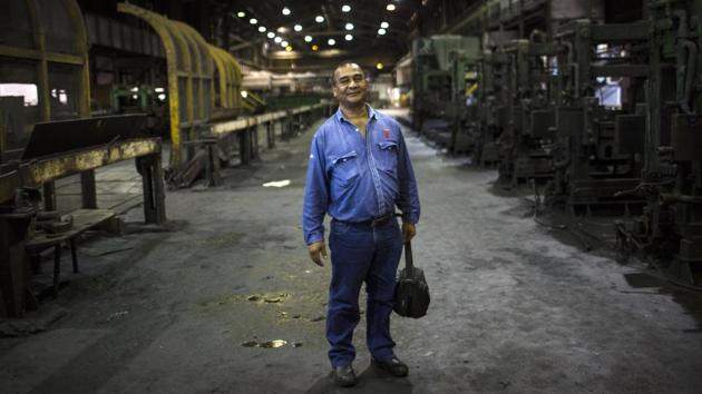 Cesar Brito poses inside Sidor’s Alambron plant where he has worked for 33 years. Venezuela sits atop the world’s largest oil reserves, but low crude prices and a plunge in production have left it in an economic free fall. (Rodrigo Abd / AP) 