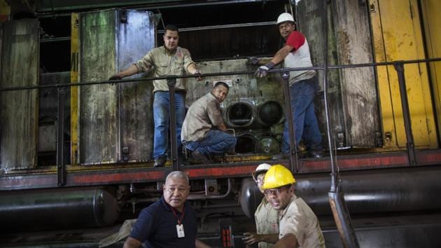 Workers repair a locomotive with salvaged parts at Ferrominera as there’s no money to buy spare parts. Meanwhile, Sidor has been eking out more than the year before, raising hopes of a shifting trend, despite Venezuela’s lack of hard currency and US sanctions that officials say are starving factories of resources. (Rodrigo Abd / AP) 