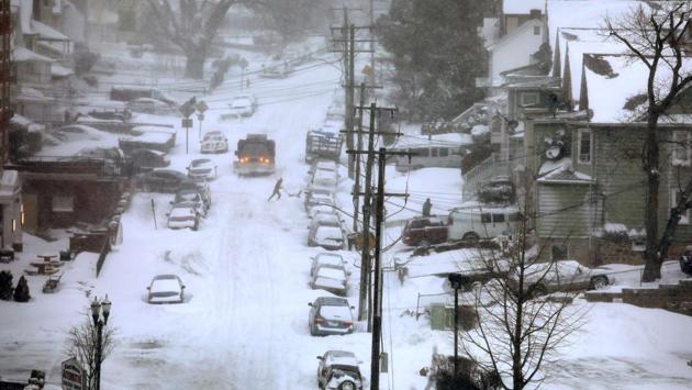 A resident clears snow in front of his house on Thursday in Stamford, Connecticut. Wind gusts of up to 88.5 kph were expected through Friday on Long Island and southeastern Connecticut, with wind chills as low as - 29 C, increasing the risk of frostbite and hypothermia from prolonged exposure. (John Moore / Getty Images / AFP)