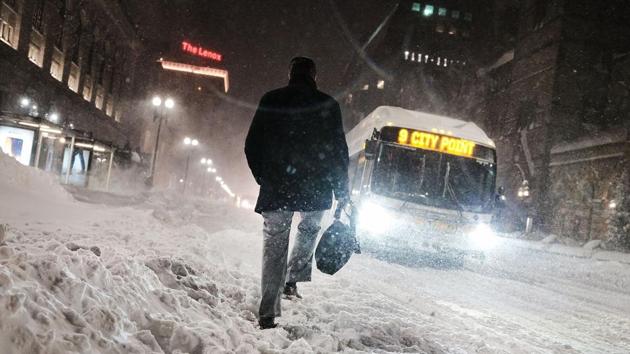 A man walks through the snowed out streets of Boston on Thursday. The area received 12 inches of snow, with more on the way, according to the National Weather Service and parts of New Jersey were also buried under nearly a foot and a half. (Spencer Platt / Getty Images / AFP)