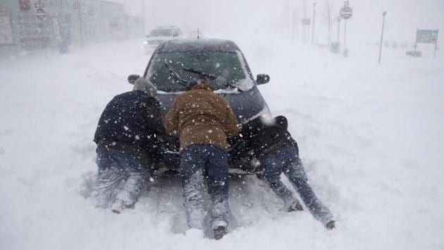 A group of men help a motorist after his car was stuck in the snowstorm near Asbury Park, New Jersery. Four people were reported killed in the southeastern states of North and South Carolina, where icy roads sent vehicles skittering. A cold wave gripping a large section of the United States had already been blamed for a dozen earlier deaths. (Julio Cortez / AP)