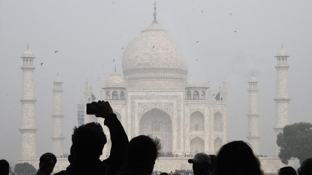 Visitors take a photo in front of the Taj Mahal in Agra. India will restrict the number of daily visitors to the Taj Mahal in an effort to preserve the iconic 17th-century monument. (Dominique Faget / AFP) Visitors take a photo in front of the Taj Mahal in Agra. India will restrict the number of daily visitors to the Taj Mahal in an effort to preserve the iconic 17th-century monument. (Dominique Faget / AFP)