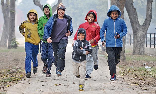 Children enjoying the cold and foggy weather in Chandigarh on Saturday.(Ravi Kumar/HT)