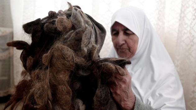 Ezzeya Daraghmeh, an 82-year-old Palestinian who claims she has kept locks of her hair over 67 years, holds her collected hair as she stuffs it in a pillow, on January 2, 2018 in the West Bank town of Tubas. (Raneen Sawafta / REUTERS) Ezzeya Daraghmeh, an 82-year-old Palestinian who claims she has kept locks of her hair over 67 years, holds her collected hair as she stuffs it in a pillow, on January 2, 2018 in the West Bank town of Tubas. (Raneen Sawafta / REUTERS)