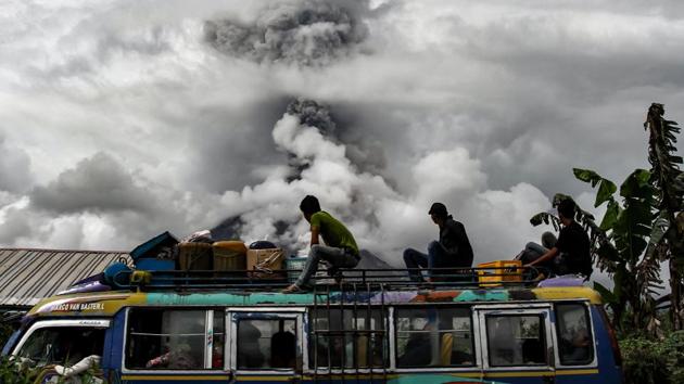 Passengers on a bus watch as Mount Sinabung spews thick smoke on January 02, 2018 in Karo, Indonesia. (Ivan Damanik / AFP) Passengers on a bus watch as Mount Sinabung spews thick smoke on January 02, 2018 in Karo, Indonesia. (Ivan Damanik / AFP)
