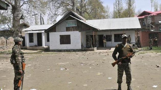 Paramilitary soldiers stand guard inside a polling station in Chadoora, in Budgam district in Srinagar.(HT File Photo)