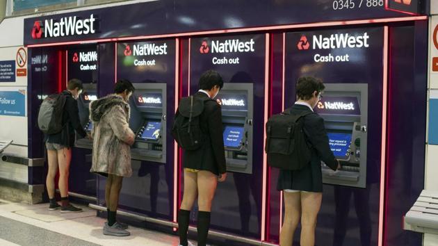 Men use cash machines at Liverpool Street station as they take part in No Trousers on the Tube day in London. Key to a successful No Pants Subway Ride is behaving as if participants do not know each other. (Dominic Lipinski / AP) 