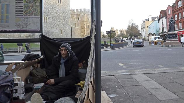 Stuart, no surname given, with his possessions in a bus stop near Windsor Castle, in background, in Windsor, England. A political storm is brewing ahead of Prince Harry and Meghan Markle's May 19 wedding over whether to crack down on homeless people and beggars in the well-to-do English town of Windsor. (AP Photo) Stuart, no surname given, with his possessions in a bus stop near Windsor Castle, in background, in Windsor, England. A political storm is brewing ahead of Prince Harry and Meghan Markle's May 19 wedding over whether to crack down on homeless people and beggars in the well-to-do English town of Windsor. (AP Photo)