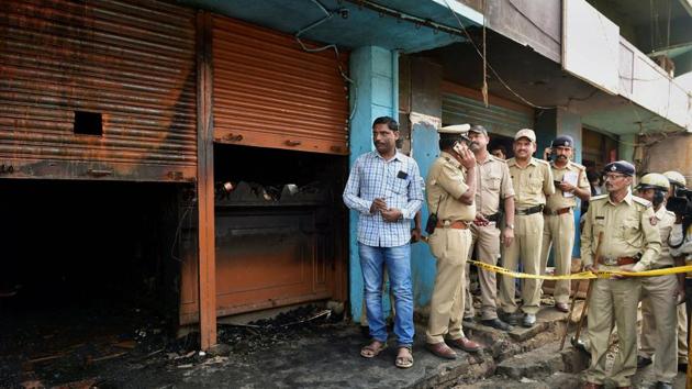 Police officers stand guard at the site after a fire broke out at a bar-cum-restaurant, in Bengaluru. (PTI Photo) Police officers stand guard at the site after a fire broke out at a bar-cum-restaurant, in Bengaluru. (PTI Photo)