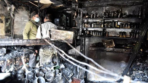 A forensic official inspects the burnt Kailash Bar and Restaurant at the Kalasipalya market area in Bengaluru. Five people who were sleeping inside the bar were killed when the blaze engulfed it. (Arijit Sen / HT Photo)