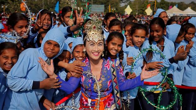 Sarjiyanto Helmi Ginanti, a kite-flier from Bali, Indonesia poses with schoolchildren on day one of the festival. This year about 535 kite fliers are participating in the festival. (Amit Dave / REUTERS)
