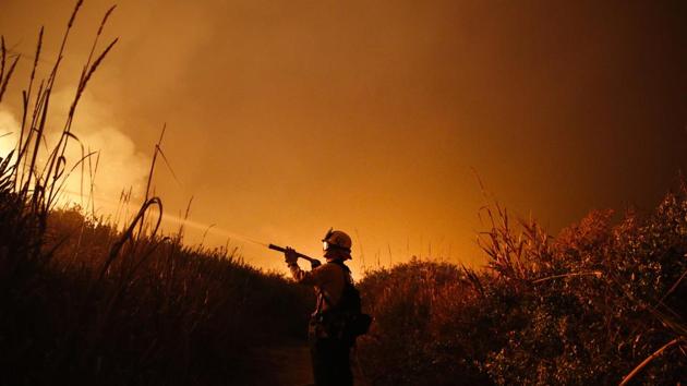In this Dec 7, 2017 photo, a firefighter battles a wildfire as it burns along a hillside toward homes in La Conchita, California. With three strong hurricanes, wildfires, hail, flooding, tornadoes and drought, supersized weather disasters tallied a record high bill for America in 2017: $306 billion. (AP File Photo) In this Dec 7, 2017 photo, a firefighter battles a wildfire as it burns along a hillside toward homes in La Conchita, California. With three strong hurricanes, wildfires, hail, flooding, tornadoes and drought, supersized weather disasters tallied a record high bill for America in 2017: $306 billion. (AP File Photo)