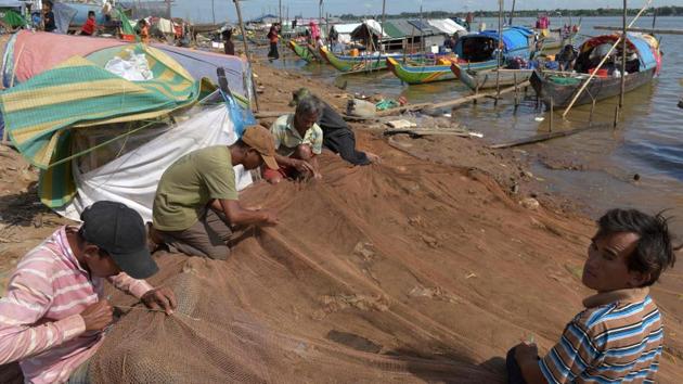 Cambodian men fix nets along the Mekong river in Phnom Penh. A powerful bargaining chip, displayed in 2016 when China opened dam gates on its soil to help Vietnam mitigate a severe drought showed that China can also modulate water levels. (Tang Chhin Sothy / AFP) Cambodian men fix nets along the Mekong river in Phnom Penh. A powerful bargaining chip, displayed in 2016 when China opened dam gates on its soil to help Vietnam mitigate a severe drought showed that China can also modulate water levels. (Tang Chhin Sothy / AFP)