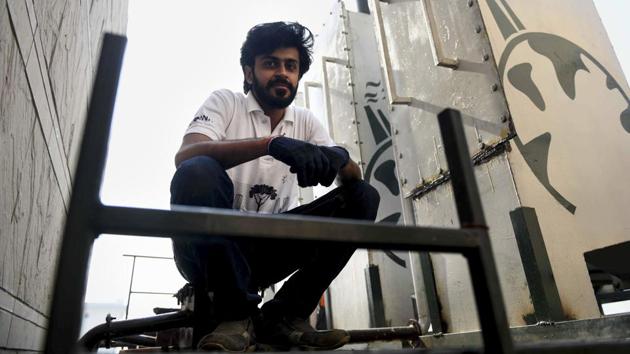 Arpit Dhupar, co-founder and CTO at Chakr, poses near a Chakr Shield that can be retrofitted to diesel generators, capturing 90% of particulate matter. Started by graduates from the Indian Institute of Technology, Chakr capitalises on converting carbon and other fine particles including PM0.3 and PM2.5 into liquified soot. Captured carbon is washed down with a solvent and processed into ink and paints. (Money Sharma / AFP) 
