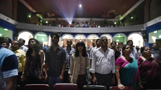 People stand while the national anthem is played before a movie at Regal cinema, New Delhi. The Supreme Court today said playing the national anthem in cinema halls is not mandatory, a day after the government asked the top court to put on hold its November 2016 order. (Raj K Raj / HT Photo)