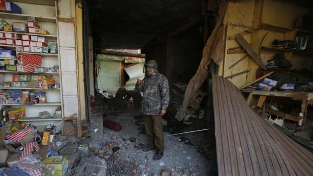 A policeman inspects the site of an IED blast in Sopore, 55 km north of Srinagar, in which four policemen were killed on January 6.(HT Photo)