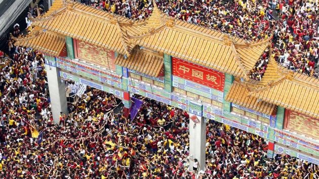 The raucous procession of the image of the Black Nazarene enters the arch landmark of Manila's Chinatown during its celebration of its feast day on January 9, 2018, in Manila, Philippines.(AP/Bullit Marquez)