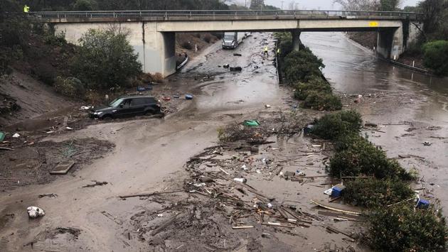 Abadoned cars stuck in flooded water on the freeway after a mudslide in Montecito. Last month’s wildfires, the largest in California history, left the area vulnerable to mudslides. The fires burned away grass and shrubs that hold the soil in place and also baked a waxy layer into the earth that prevents water from sinking deep into the ground. (Mike Eliason / Santa Barbara News-Press / REUTERS) 