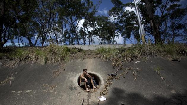 David Garcia, smokes a cigarette during a break on his first week of scavenging. Scavengers like David and Angel dream of better jobs, or leaving Venezuela for better prospects like thousands others. But for now they test their luck scavenging in the Guaire. (Ariana Cubillos / AP) David Garcia, smokes a cigarette during a break on his first week of scavenging. Scavengers like David and Angel dream of better jobs, or leaving Venezuela for better prospects like thousands others. But for now they test their luck scavenging in the Guaire. (Ariana Cubillos / AP)
