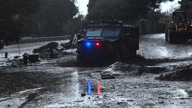 A police vehicle drives across a flooded side road off the US 101 freeway in Montecito. Roads were clogged throughout the region with mudflows shutting down more than 50 kilometers of the 101 Freeway and knocking a number of homes from their foundations. (Frederic J. Brown / AFP) 